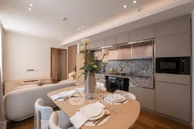 Modern open-plan kitchen and dining area with elegant decor and integrated appliances.