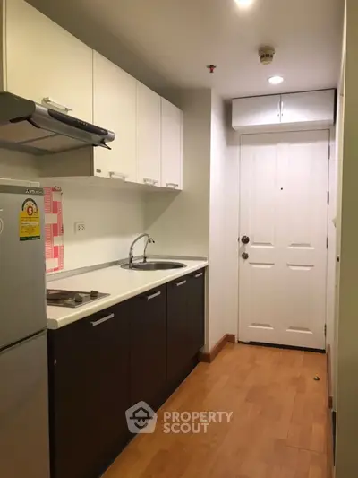 Modern compact kitchen with sleek cabinets and wood flooring