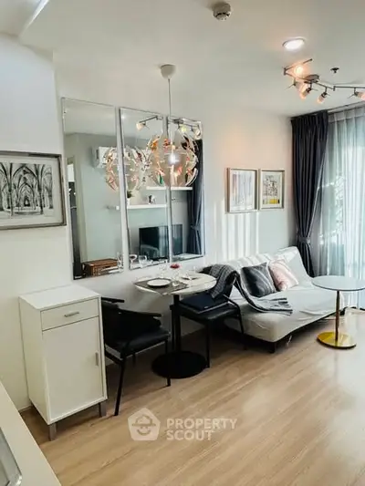 Modern living room with stylish decor and natural light, featuring a cozy seating area and elegant wall art.