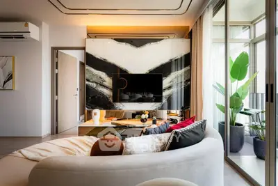 Luxurious modern living room with stylish decor and large windows opening to a balcony.