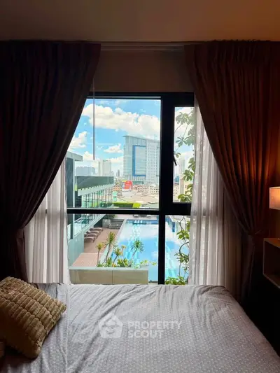 Luxurious bedroom with stunning city view and pool access, perfect for urban living.