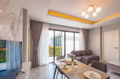 Modern living room with elegant dining area and large windows for natural light.