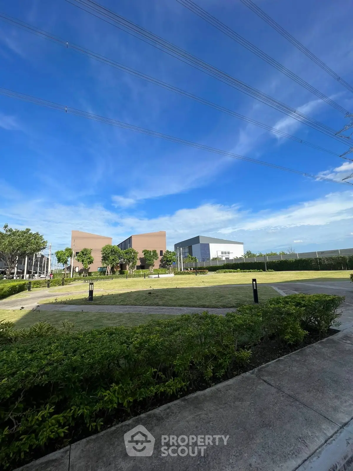 Stunning modern building with lush green surroundings under a clear blue sky.