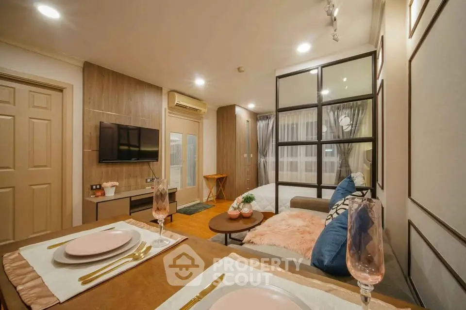 Modern open-plan living room with stylish decor and cozy bedroom area
