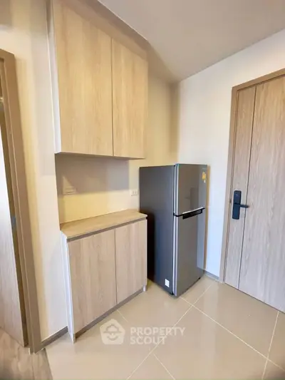 Modern kitchen corner with sleek fridge and wooden cabinets