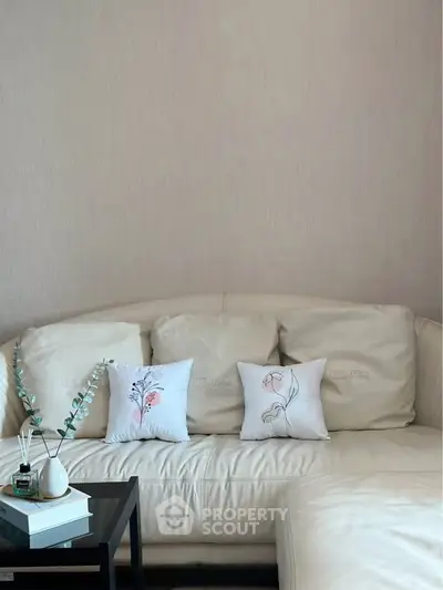Elegant living room with plush white sofa and decorative pillows, perfect for modern comfort and style.