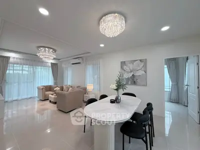 Elegant open-plan living room with modern chandelier and stylish dining area