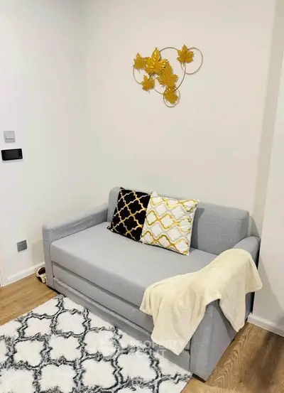 Cozy living room with stylish gray sofa, decorative pillows, and elegant wall art, perfect for modern living.