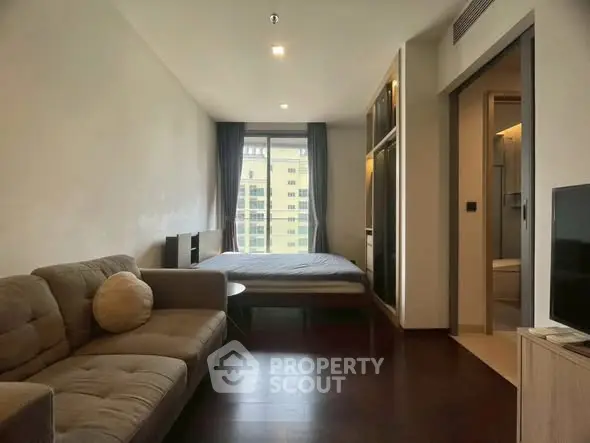 Modern studio apartment with cozy living area and large window view