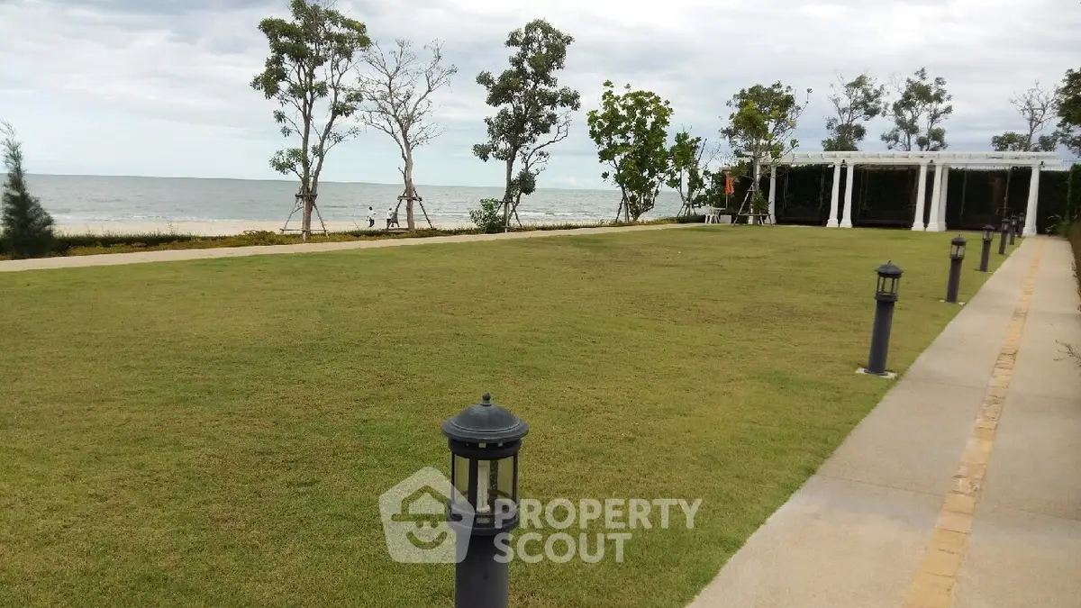 Stunning beachfront garden with ocean view and elegant pathway lighting.