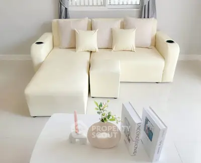 Stylish modern living room with cream sofa and chic decor accents.