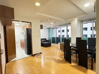 Spacious open-plan living and dining area with modern furnishings and large windows.