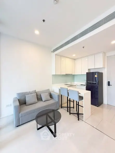 Modern open-layout kitchen and living room with sleek design and cozy seating area.