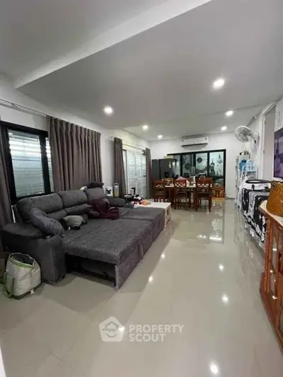 Spacious modern living room with sleek furniture and dining area, perfect for family gatherings.