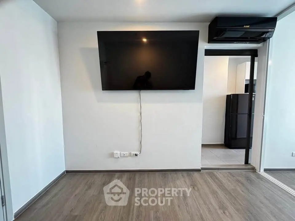 Modern living room with wall-mounted TV and sleek flooring