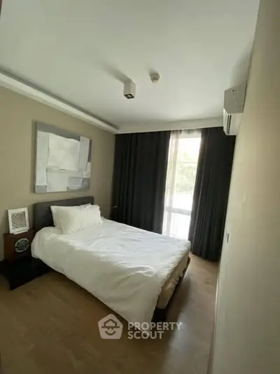 Cozy bedroom with modern decor and large window for natural light