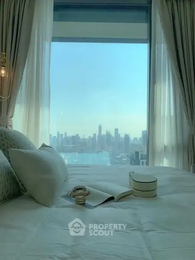 Luxurious bedroom with stunning city skyline view from large window.