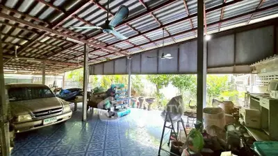 Spacious covered garage with ample storage and natural light, perfect for multiple vehicles and versatile use.