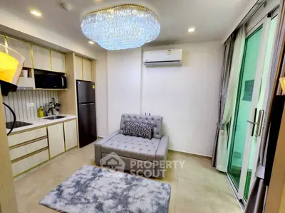Modern living room with elegant chandelier and cozy seating area in a stylish apartment.