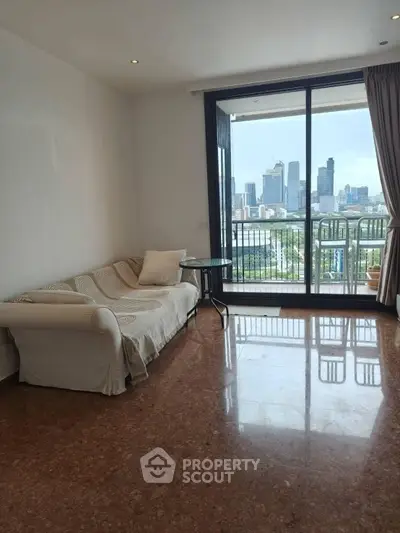 Spacious living room with city skyline view and balcony access