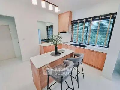 Modern kitchen with island, sleek cabinetry, and stylish lighting in a bright, airy space.