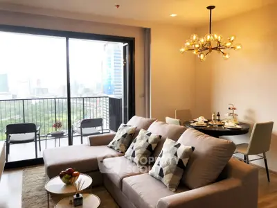 Modern living room with stylish chandelier and city view balcony in luxury apartment
