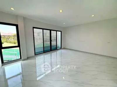Spacious modern living room with large windows and glossy tiled floor
