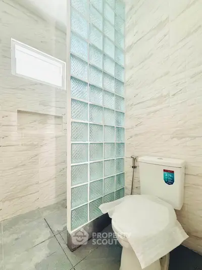 Modern bathroom with glass block partition and sleek tile design