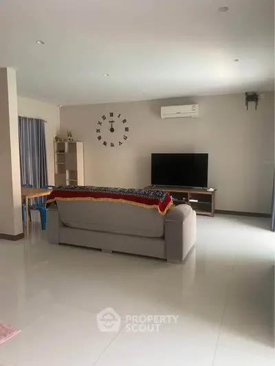 Spacious living room with modern decor and wall-mounted air conditioning unit.
