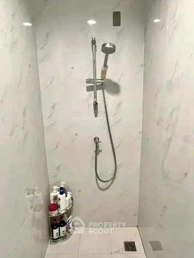 Modern bathroom shower with sleek marble tiles and built-in showerhead, perfect for a luxurious home.