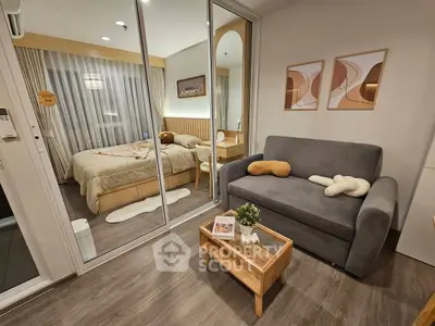 Cozy modern living room with sofa and view into stylish bedroom through glass partition.