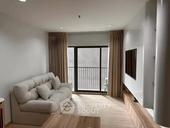 Modern living room with cozy sofa and large window for natural light.