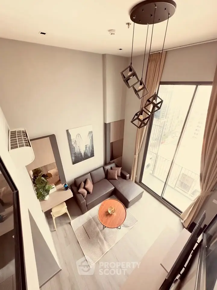Modern living room with high ceiling and large windows offering a stunning city view, featuring stylish decor and cozy seating.