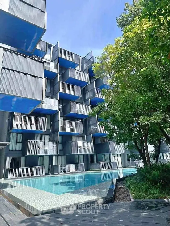 Modern architectural building with unique balconies and poolside view