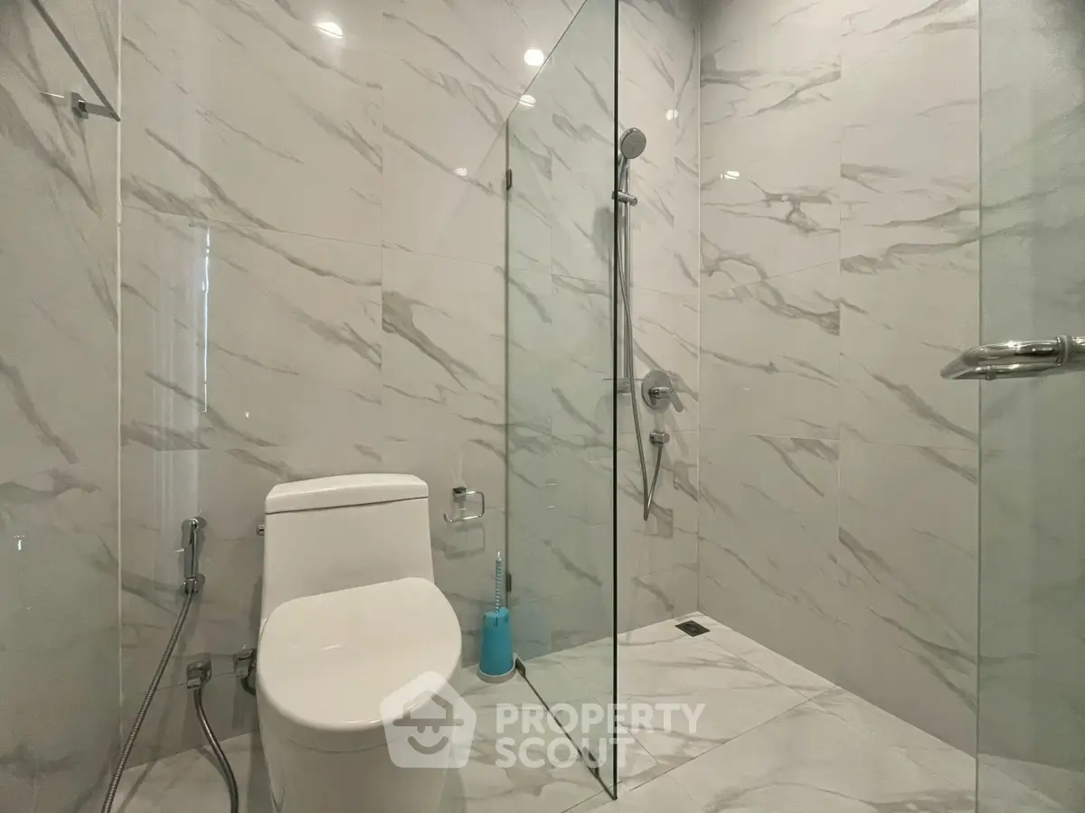 Modern bathroom with sleek glass shower and elegant marble tiles