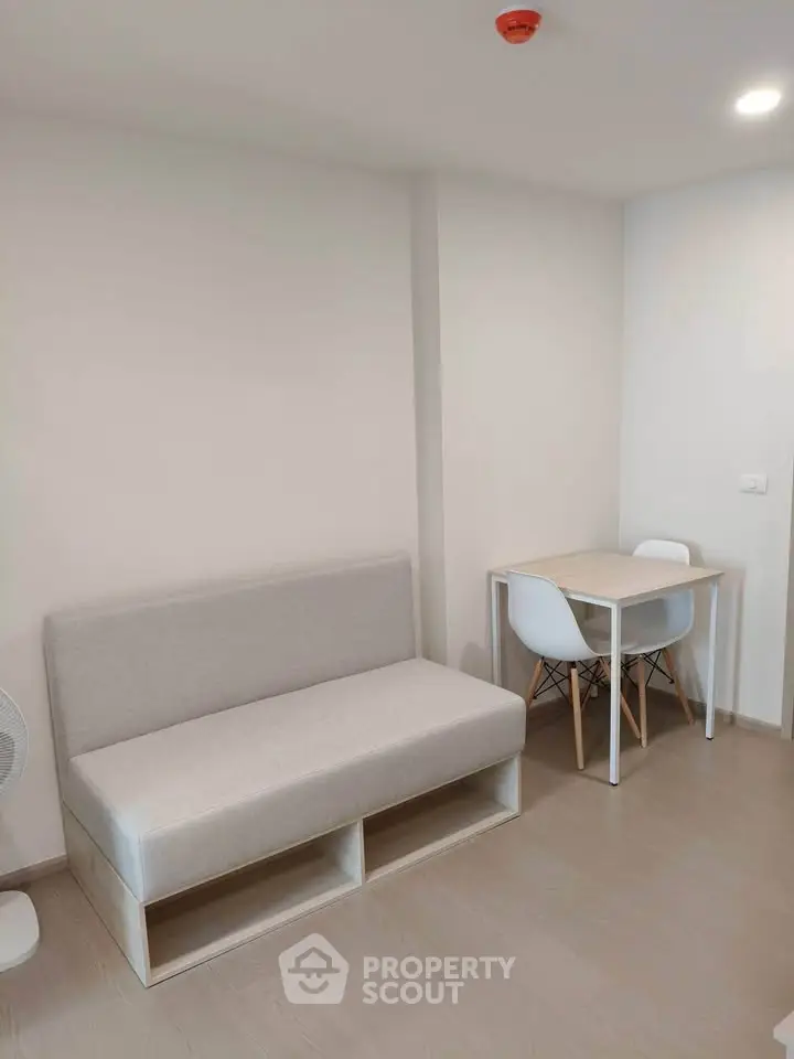 Modern minimalist living room with compact sofa and dining table, perfect for urban living.