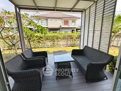 Charming outdoor patio with stylish wicker furniture and garden view, perfect for relaxation.
