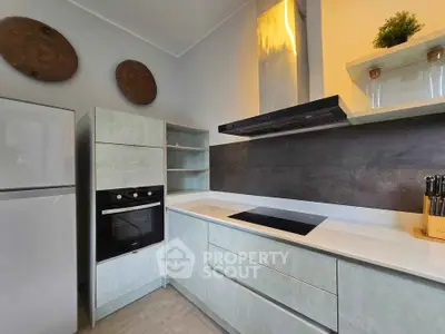 Modern kitchen with sleek cabinetry, built-in oven, and induction cooktop, perfect for culinary enthusiasts.