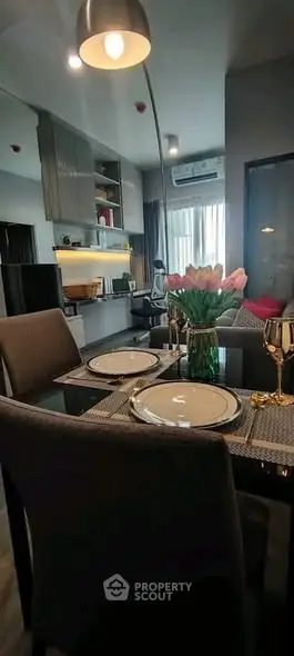 Modern dining area with elegant table setting and stylish kitchen in open layout apartment.