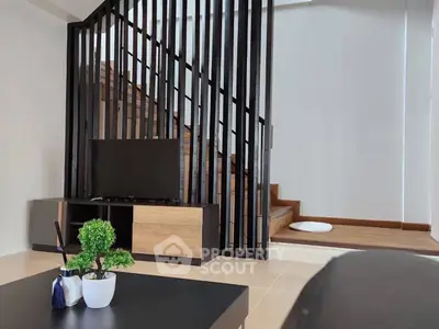 Modern living room with stylish staircase and sleek TV stand, perfect for contemporary urban living.