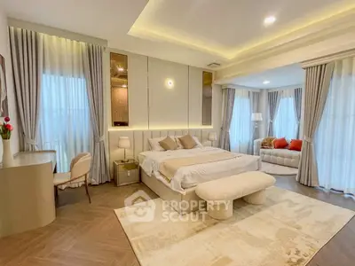 Luxurious bedroom with elegant decor and spacious layout, featuring a cozy seating area and modern lighting.