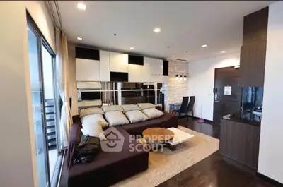 Modern living room with stylish decor and open layout, featuring a cozy sectional sofa and sleek dining area.