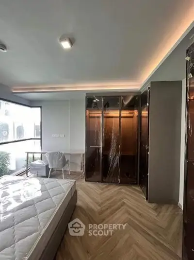Modern bedroom with large window and stylish wardrobe in a contemporary apartment.