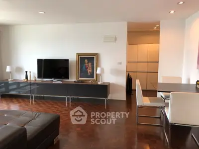 Spacious modern living room with elegant decor and parquet flooring, featuring a sleek entertainment unit and dining area.
