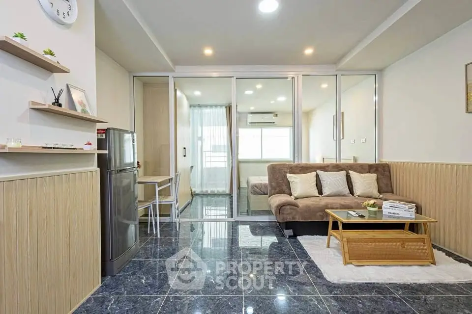 Modern living room with sleek design and glass partition, featuring cozy sofa and stylish decor.