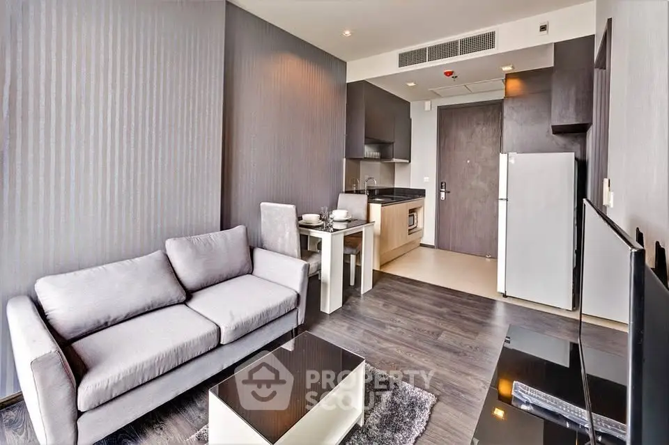 Modern living room with open kitchen, sleek furniture, and stylish decor in a contemporary apartment.