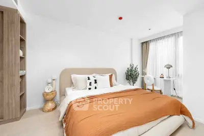 Modern bedroom with stylish decor and natural light, featuring a cozy bed and elegant furnishings.