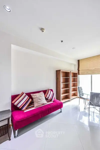 Bright living room with vibrant pink sofa and modern decor