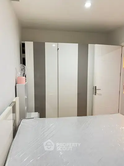 Modern bedroom with sleek white wardrobe and minimalistic decor