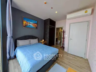 Modern bedroom with large window and stylish decor in a cozy apartment.